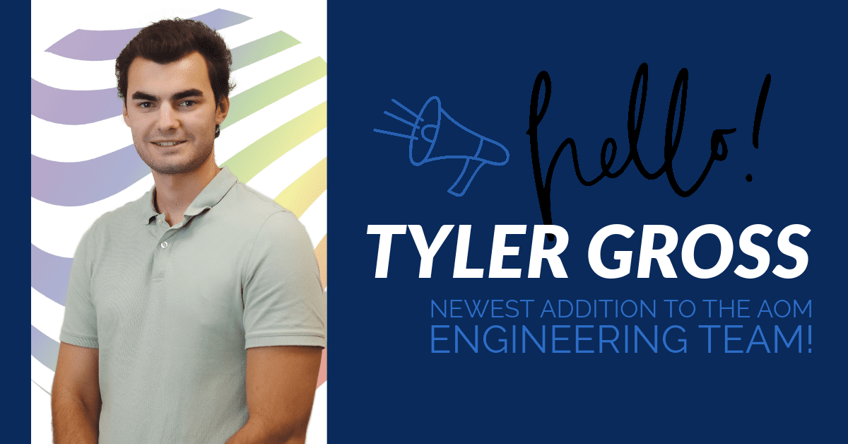 Welcome Tyler G Photo of Tyler in front of the AOM rainbow hologram with the words, "hello! Tyler Gross newest addition to the AOM engineering team.
